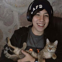 Image of Quackity smiling with his cat Tiger.